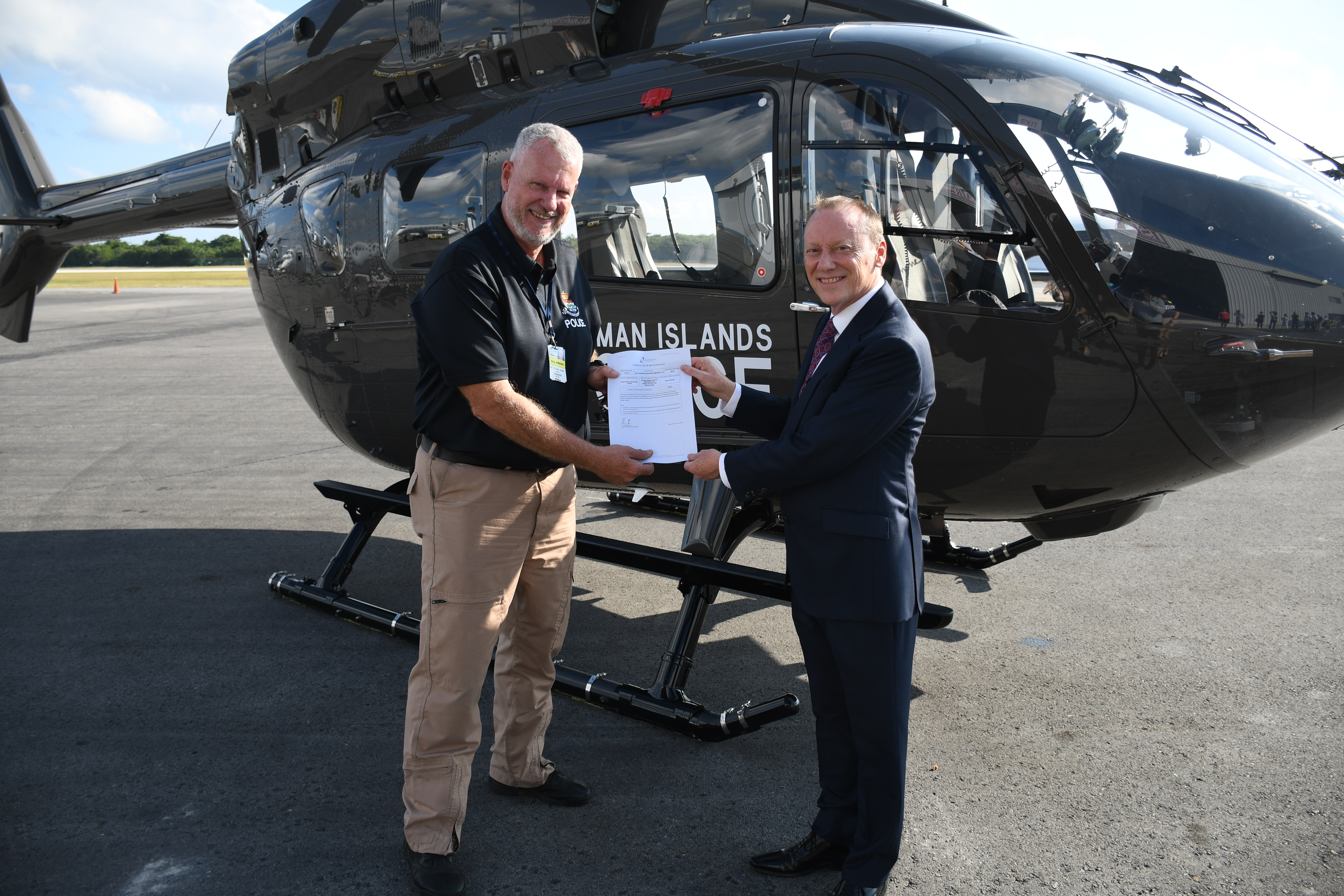 Head of the RCIPS Air Operations Unit Steve Fitzgerald receives the registration certificate for the new H145 from His Excellency the Governor Martyn Roper.